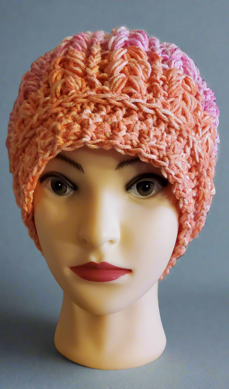 Crocheted pink and orange women's hat, soft and elegant fashion accessory.