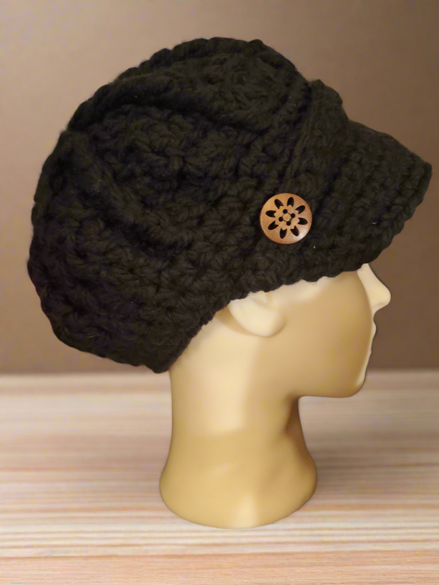 Black newsboy hat crocheted with buttons on mannequin.