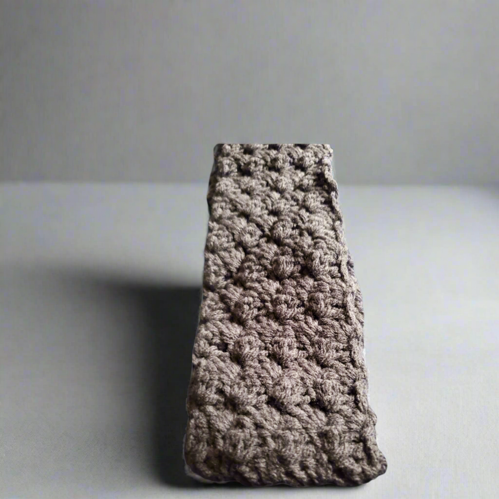 Handmade crocheted headband in gray, stylish winter accessory for women.