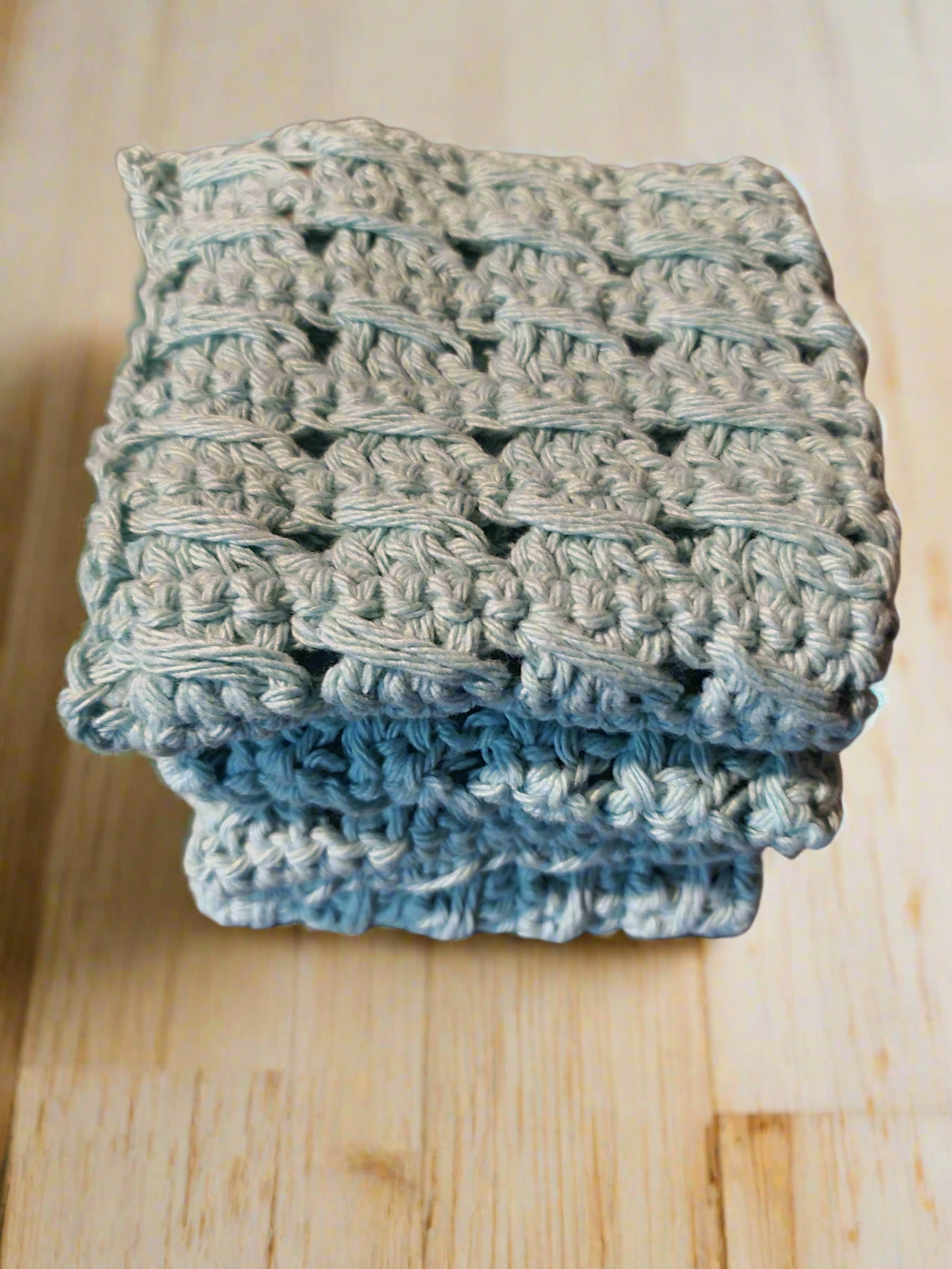 Handmade textured aqua dishcloths set of 4 on a wooden surface.