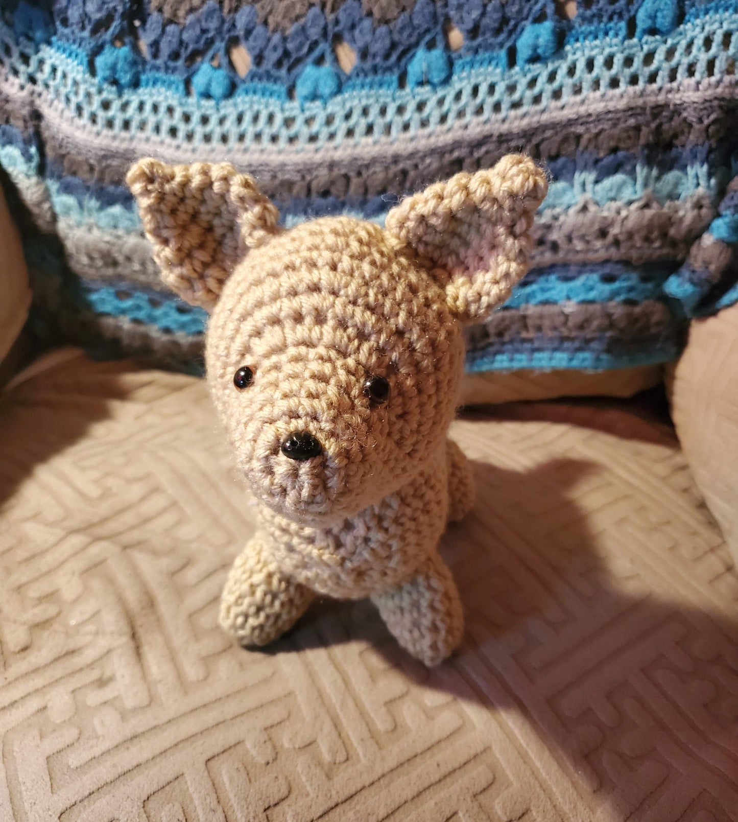 Stuffed Dog Chihuahua on a patterned couch.