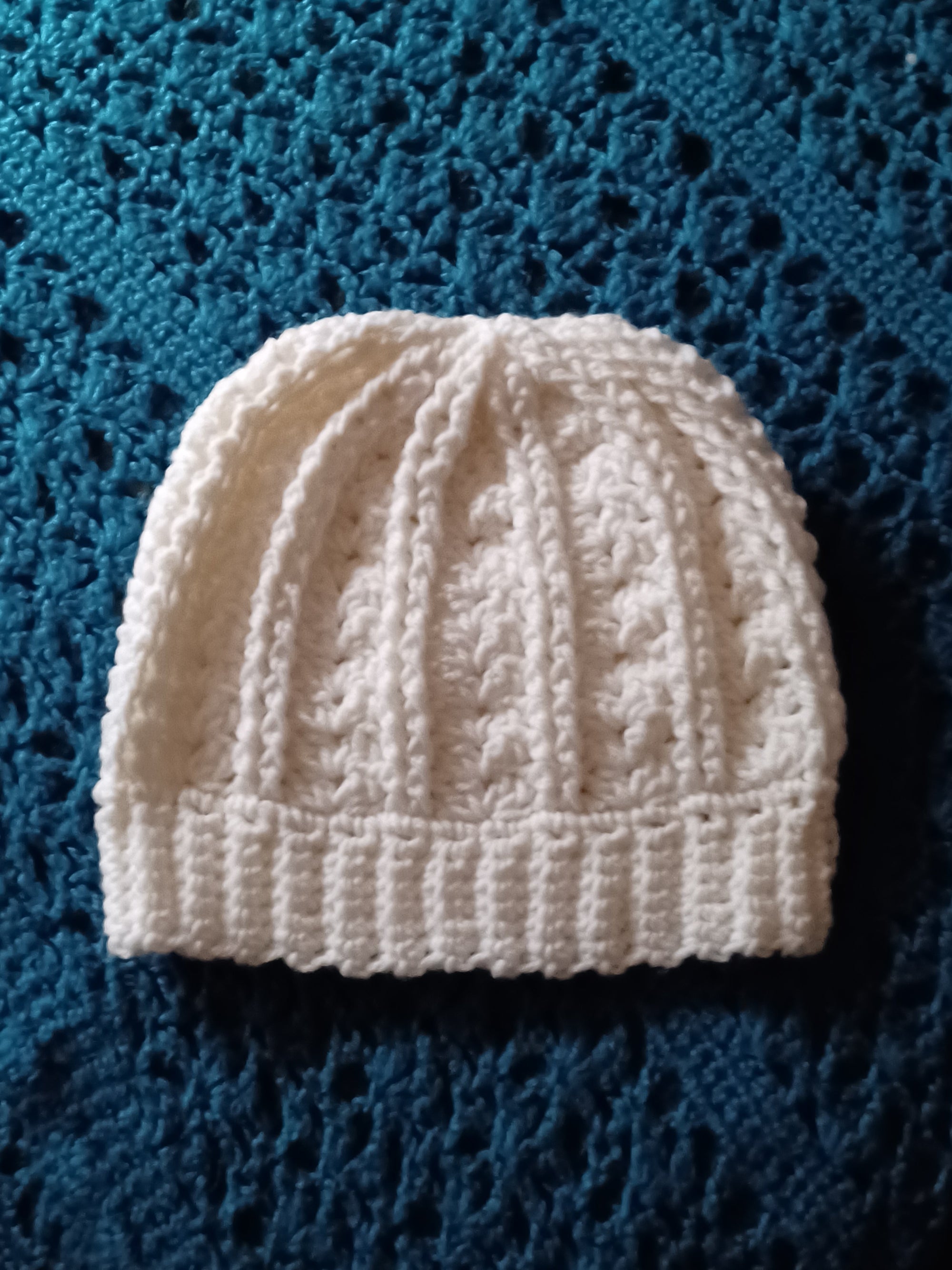 Handmade white crocheted beanie hat for men or women, simple style.