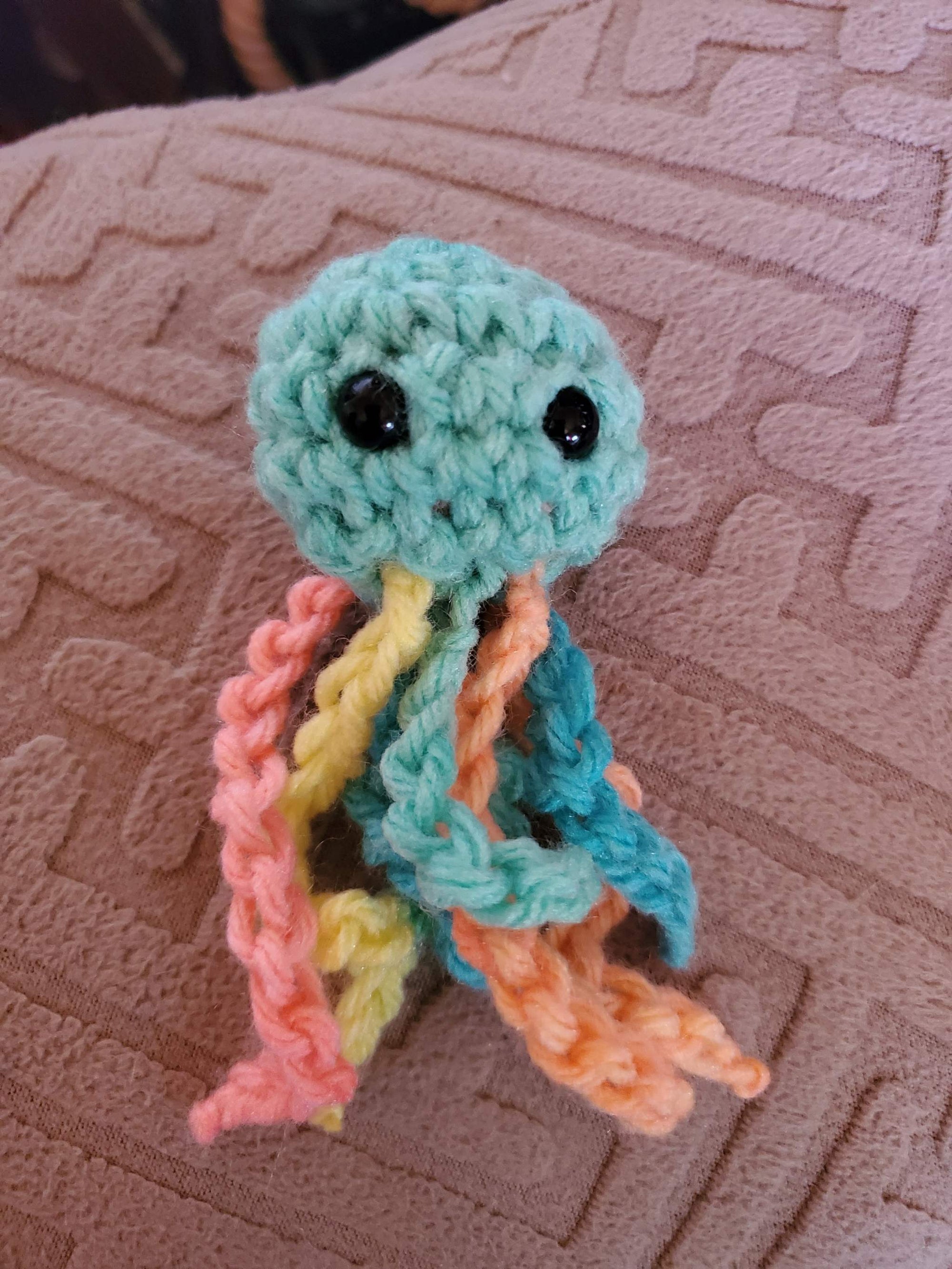 Adorable handmade crocheted baby stuffed jellyfish toy in vibrant colors.