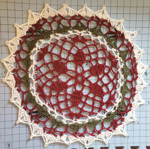 Red, green, and white Christmas doily for festive home decoration.