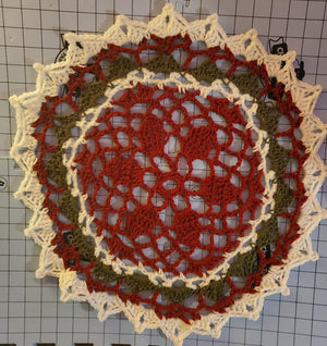 Red, green, and white Christmas doily for festive home decoration.