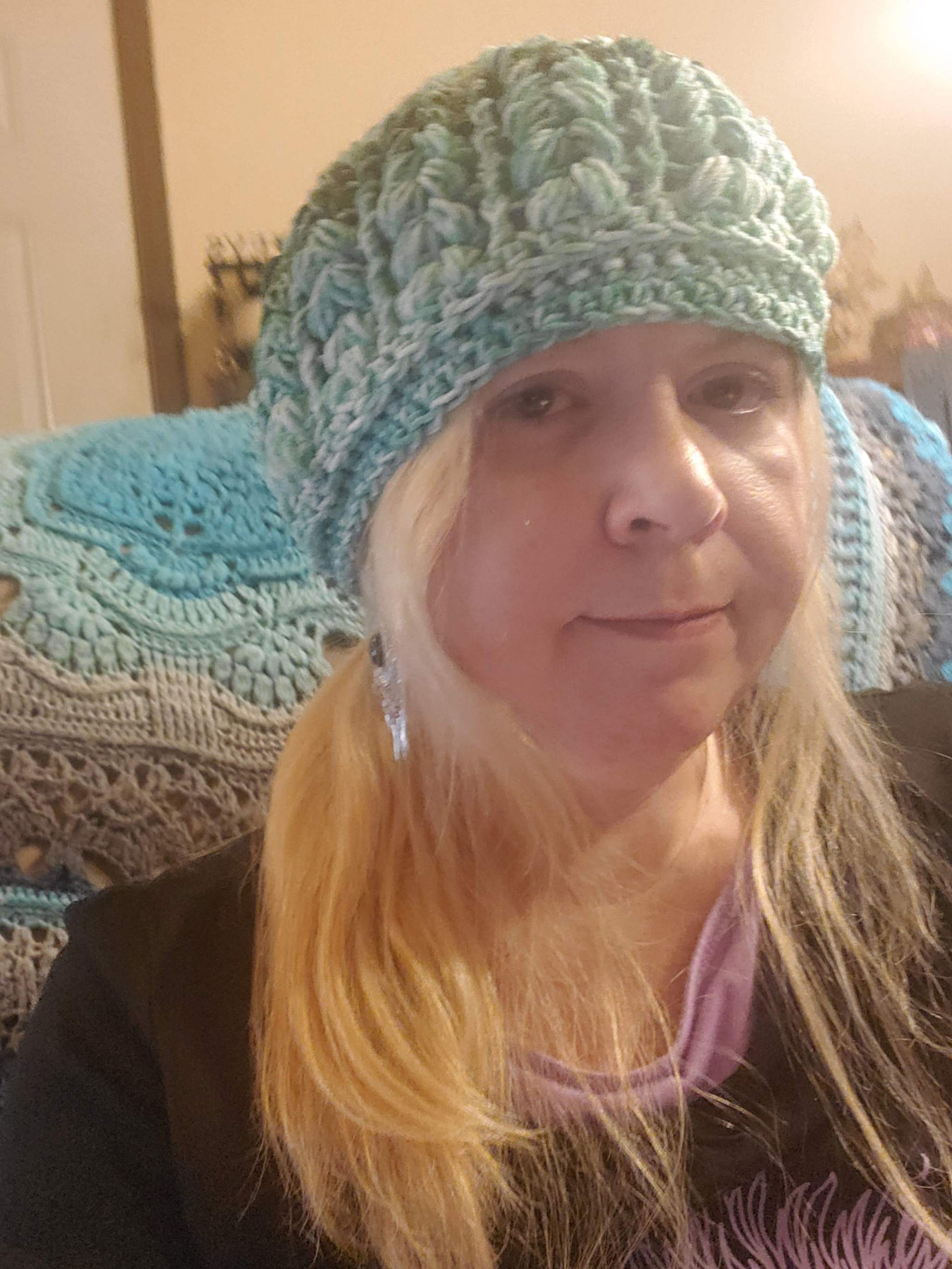 Crocheted Green Ombre Beanie Hat worn by a person, showcasing its stylish and elegant design.