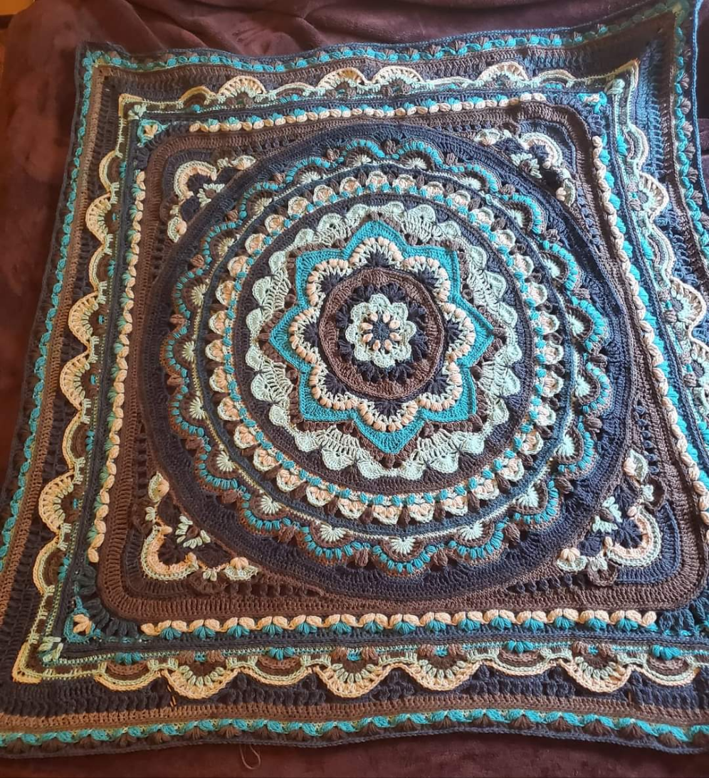 Colorful mandala afghan with intricate patterns and design.