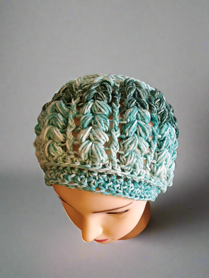 Crocheted green ombre beanie hat, stylish and soft fashion accessory.