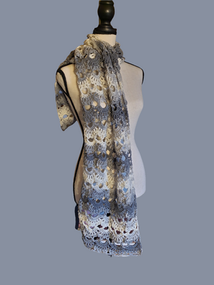 Gray and white handmade crocheted scarf with intricate design.