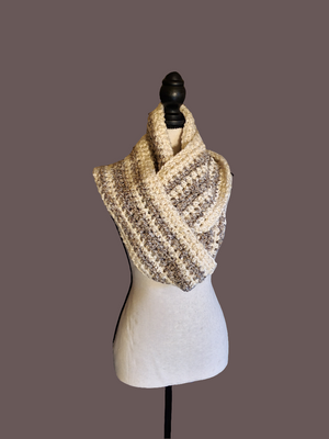 Soft thick handmade crocheted gray and white infinity scarf on display.