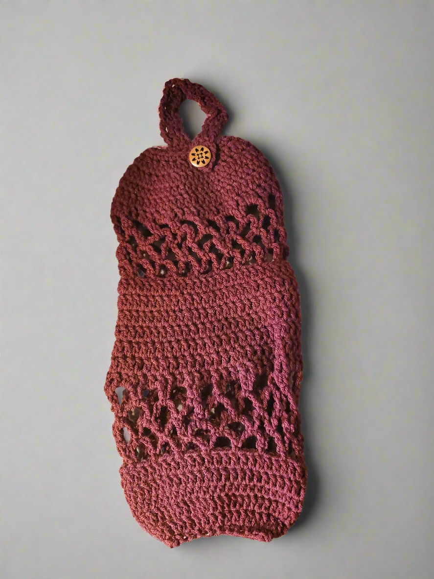 Handmade crocheted acrylic plastic bag holder with a hanging loop for organizing bags.