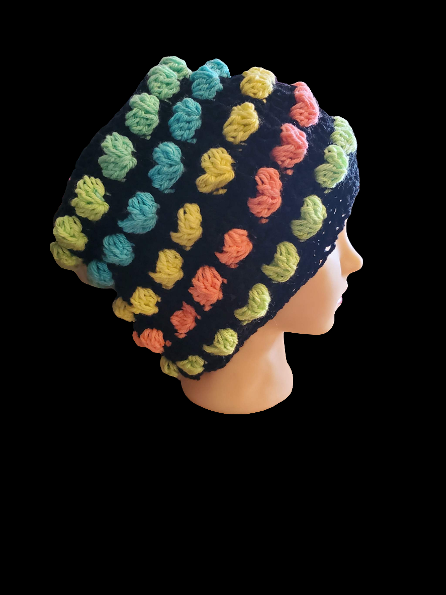 Crochet hat with colorful rainbow heart patterns.