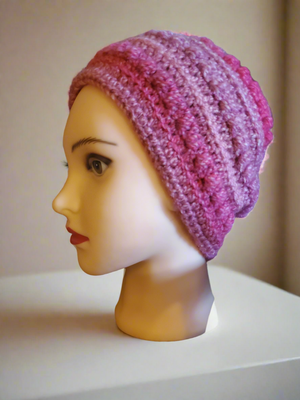 Beautifully crocheted soft pink hat displayed on mannequin.