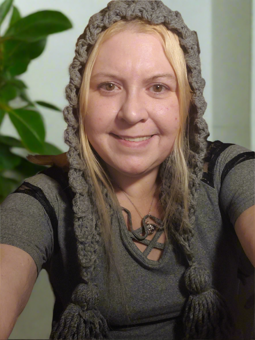 Handmade gray crocheted tassel hat with ear flaps for women.