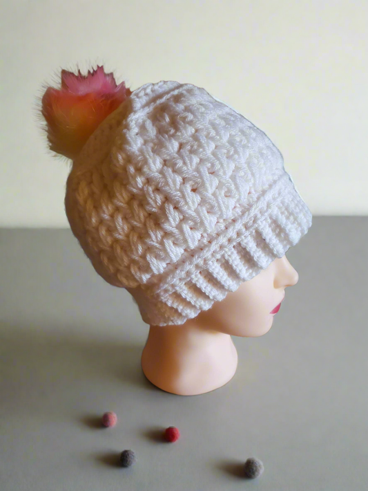 Handmade crocheted white feather stitch hat with rainbow pompom for women.