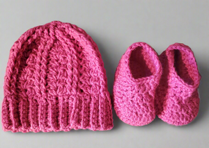 Adorable pink baby hat and booties set, cozy and super-soft.