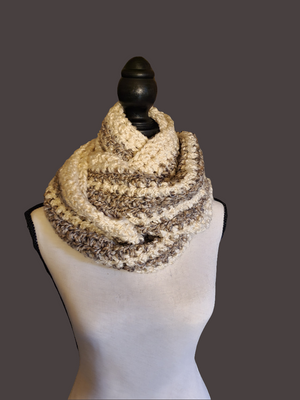 Soft thick handmade crocheted gray and white infinity scarf for women on display.