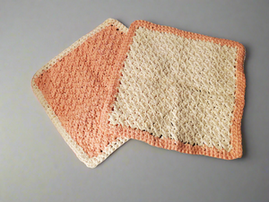 Crocheted cream and tangerine colored dishcloths - set of 4, showcasing intricate stitching and texture for kitchen cleaning.