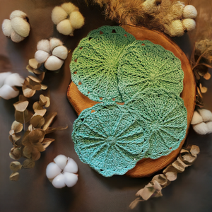 Set of 4 aqua handmade crocheted cotton dishcloths on a wooden tray with cotton plants.