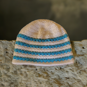 Blue and white handmade star stitch beanie on textured surface.