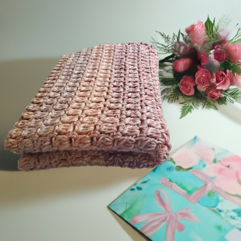 Handmade crocheted pink baby blanket soft and cozy for baby girl.