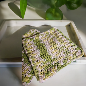 Handmade green and white crocheted dishcloths for home cleaning.