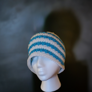 Blue and white handmade star stitch beanie displayed on a mannequin.