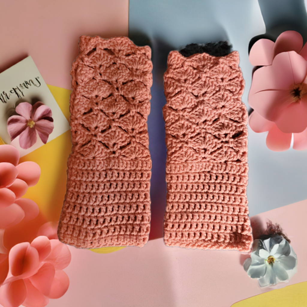 Fancy pink shell stitch fingerless gloves for women on decorative surface.