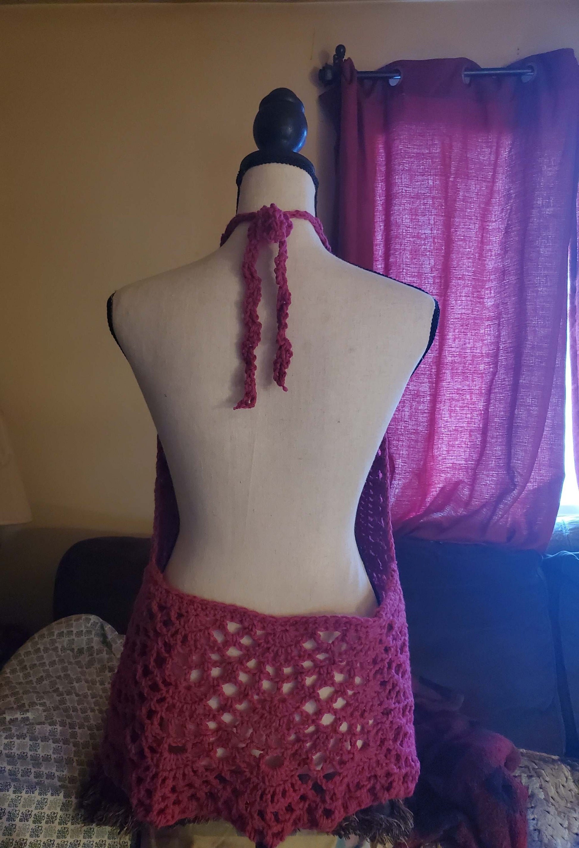 Pink lacy crochet halter top with scalloped lace hem on mannequin.